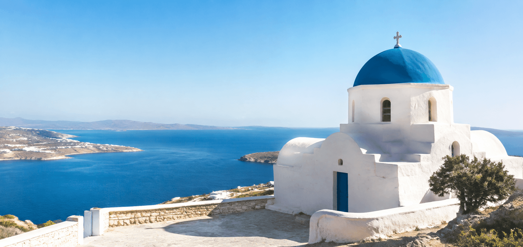 A white chapel above the turquoise Aegean Sea